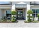 Elegant front entrance with decorative landscaping and a stylish gray double door at 7928 Redonda Loop, Bradenton, FL 34202