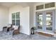 Inviting front porch with seating area and stylish gray double door at 7928 Redonda Loop, Bradenton, FL 34202