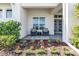 Inviting front porch with seating area and colorful flower garden at 7928 Redonda Loop, Bradenton, FL 34202