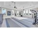 The fitness center with large windows offers natural light, ceiling fans, and essential equipment for an invigorating workout experience at 7928 Redonda Loop, Bradenton, FL 34202