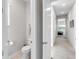 Hallway with a powder room visible and a partial view of a bedroom in the distance at 7928 Redonda Loop, Bradenton, FL 34202