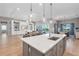 Open-concept kitchen with a large island, pendant lighting, and views of the living area and pool at 7928 Redonda Loop, Bradenton, FL 34202