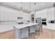 Bright kitchen featuring white cabinets, a large island with seating, and modern appliances at 7928 Redonda Loop, Bradenton, FL 34202