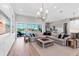 Spacious living room features hardwood floors, stylish furniture, and sliding glass doors to outdoor living space at 7928 Redonda Loop, Bradenton, FL 34202