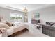 Spacious primary bedroom with a tray ceiling, chandelier, and seating area at 7928 Redonda Loop, Bradenton, FL 34202