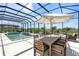 Enclosed pool area with a dining set, a fire pit, and comfortable seating at 7928 Redonda Loop, Bradenton, FL 34202