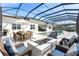 Enclosed pool area with outdoor seating, dining area, and landscaping at 7928 Redonda Loop, Bradenton, FL 34202
