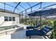 Screened-in pool area featuring a spa and blue lounge chairs under an umbrella at 7928 Redonda Loop, Bradenton, FL 34202