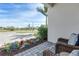 Inviting porch with wicker chairs and a small table surrounded by colorful landscaping at 7928 Redonda Loop, Bradenton, FL 34202