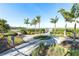 Walking path through well-maintained landscaping with decorative palm trees and water feature at 7928 Redonda Loop, Bradenton, FL 34202