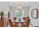 Cozy dining room with glass table, wicker chairs, buffet, crown molding, and plantation shutters at 8188 Gabanna Dr, Sarasota, FL 34231