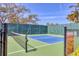 Community pickleball court surrounded by a fence and mature trees on a sunny day at 8188 Gabanna Dr, Sarasota, FL 34231