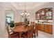 Elegant dining room featuring a wooden table, chandelier, and built-in bar area at 8215 Waterview Blvd, Lakewood Ranch, FL 34202