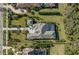 Aerial view of a luxurious home featuring manicured landscaping, a private pool, and a beautiful tile roof at 8455 Lindrick Ln, Bradenton, FL 34202