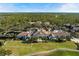 Expansive aerial view showcasing an elegant clubhouse with a tile roof, manicured lawns, and lush surroundings at 8455 Lindrick Ln, Bradenton, FL 34202