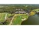 Overhead view of a golf course, highlighting a putting green, sand traps and a small lake near the clubhouse at 8455 Lindrick Ln, Bradenton, FL 34202