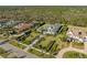 Impressive aerial shot of a luxury home with exquisite landscaping, palm trees, and a stately driveway at 8455 Lindrick Ln, Bradenton, FL 34202