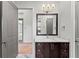 Bathroom with a dark wood vanity, marble floors, and modern lighting fixtures at 8455 Lindrick Ln, Bradenton, FL 34202