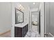 Well-lit bathroom with marble floors, modern vanity, and updated lighting at 8455 Lindrick Ln, Bradenton, FL 34202