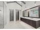 Bright bathroom with a large double sink vanity, modern fixtures, and a glass-enclosed shower with white marble tile at 8455 Lindrick Ln, Bradenton, FL 34202