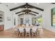 Elegant dining area with wood floors, seating for eight, and dark wood beam ceilings adding visual interest at 8455 Lindrick Ln, Bradenton, FL 34202