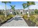 Beautiful single-story home with symmetrical palm trees lining the paver driveway and lush landscaping at 8455 Lindrick Ln, Bradenton, FL 34202