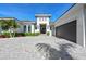 Single-story home with a three-car garage, paver driveway and lush landscaping at 8455 Lindrick Ln, Bradenton, FL 34202