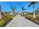 Beautiful single-story home with symmetrical palm trees lining the paver driveway and lush landscaping at 8455 Lindrick Ln, Bradenton, FL 34202