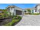 Well-maintained home with a dark brown garage door, lush landscaping, and paved driveway at 8455 Lindrick Ln, Bradenton, FL 34202