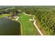 Scenic aerial view of a lush golf course with water features and manicured greens, nestled in a wooded area at 8455 Lindrick Ln, Bradenton, FL 34202