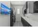 Laundry room with modern washer/dryer, ample cabinetry, counter space and tv at 8455 Lindrick Ln, Bradenton, FL 34202