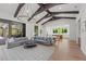 Open-concept living area with dark wood beams, modern lighting, and seamless access to the kitchen at 8455 Lindrick Ln, Bradenton, FL 34202