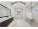 Elegant bathroom features a soaking tub under a shuttered window and marble-look tile at 8455 Lindrick Ln, Bradenton, FL 34202