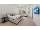 Elegant main bedroom with large windows, a crystal chandelier, and a comfortable bed at 8455 Lindrick Ln, Bradenton, FL 34202
