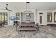 A covered outdoor kitchen and dining area featuring a built-in grill, bar seating, and a modern pendant light at 8455 Lindrick Ln, Bradenton, FL 34202