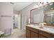Bathroom with double sinks, framed mirrors, granite counters, and a glass-enclosed shower with tiled accents at 8928 Excelsior Loop, Venice, FL 34293