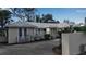 Charming exterior with a brick driveway, a white fence, and beautifully maintained landscaping at 980 S Orange Ave, Sarasota, FL 34236