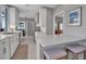 Bright, open kitchen featuring white cabinetry, stone countertops, modern appliances, and breakfast bar seating at 980 S Orange Ave, Sarasota, FL 34236