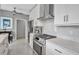 Bright kitchen features white cabinets, stone countertops, stainless steel appliances, and a gray backsplash at 980 S Orange Ave, Sarasota, FL 34236