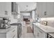 Bright, modern kitchen featuring white cabinets, stone countertops, stainless steel appliances, and open layout at 980 S Orange Ave, Sarasota, FL 34236