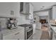 Bright kitchen featuring white cabinets, stainless steel appliances, stone countertops, and adjacent dining space at 980 S Orange Ave, Sarasota, FL 34236