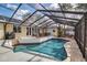 Charming screened-in pool area with a deck, lounge chairs, BBQ, and views of the light yellow house at 980 S Orange Ave, Sarasota, FL 34236