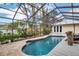 Lovely screened-in pool area with a deck, lush landscaping, and a serene atmosphere, perfect for leisure at 980 S Orange Ave, Sarasota, FL 34236