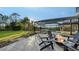 Relaxing backyard featuring a fire pit, screened pool, lake view, and lush landscaping at 9818 Old Hyde Park Pl, Bradenton, FL 34202