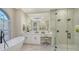 Bright bathroom with a soaking tub, dual vanities and walk-in glass shower at 9818 Old Hyde Park Pl, Bradenton, FL 34202