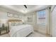Bedroom with a decorative headboard, modern art, and natural light at 9818 Old Hyde Park Pl, Bradenton, FL 34202