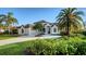 Stunning front exterior featuring a circular driveway and lush tropical landscaping at 9818 Old Hyde Park Pl, Bradenton, FL 34202