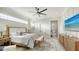 Bright main bedroom showing bed, seating area, TV and ensuite bathroom with soaking tub at 9818 Old Hyde Park Pl, Bradenton, FL 34202