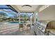 Outdoor kitchen and dining area complete with a barbecue grill, seating, and a view of the pool at 9818 Old Hyde Park Pl, Bradenton, FL 34202