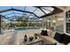 Screened-in pool area with spa, lounge chairs, and serene water views at 9818 Old Hyde Park Pl, Bradenton, FL 34202